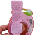Detailný záber na rozbaľovaciu viacjazyčnú etiketu, zameraný na jej slovenskú časť (SK). Text detailne popisuje zloženie produktu, v ktorom je zastúpený glukózový sirup, cukor, 10 % koncentrát broskyňovej šťavy a hovädzia želatína. V spodnej časti je uved