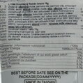 Detailný close-up na slovenskú lokalizovanú etiketu prilepenú na obale produktu Chrumkavý Ramen Snack 75g. Etiketa obsahuje slovenský zoznam zložiek, zvýraznené alergény (pšenica, sója), upozornenie o stopách rýb a kôrovcov, odporúčania na skladovanie a č
